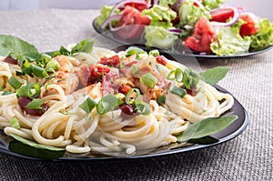 Home-cooked meals on a gray mat - spaghetti and vegetable salad