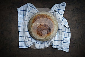 Home cooked round bread, on a dark background. View from above