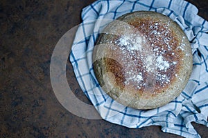 Home cooked round bread, on a dark background. View from above
