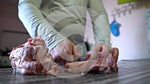 Home Cooking Food, Pork Meat. Man Cuts Pork Meat With Knife In Home Kitchen. Man's Hand Holds a Knife. Chef Cutting Meat