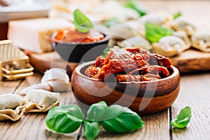 Home cooking - raw tortellini pasta with tomato pesto and sun-dried tomatoes and basil