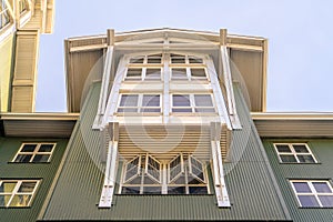 Home with cottage pane windows and gable roof viewed from below against sky