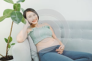 Home cozy portrait of pregnant woman resting at home on sofa