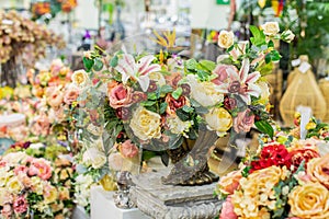 Home decor with artificial flowers, rose lily leaves. Elegant bouquet for home decor, yellow rose in a dark metal vase. Interior