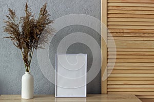 Home decor mockup, blank photo frame near gray painted concrete wall. Place for your text