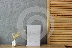 Home decor mockup, blank photo frame near gray painted concrete wall. Place for your text