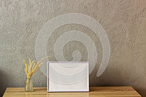 Home decor mockup, blank photo frame near gray painted concrete wall. Place for your text