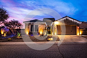 A home decorated with Christmas Lights with a dramatic evening sky