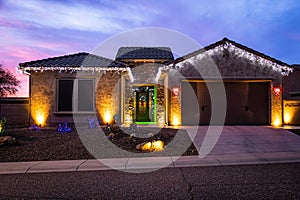 A home decorated with Christmas Lights with a dramatic evening sky