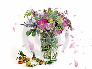Beautiful  Wild flowers bouquet  rose hip petal  pink green yellow blue in glass vase and rose hip berry on white background