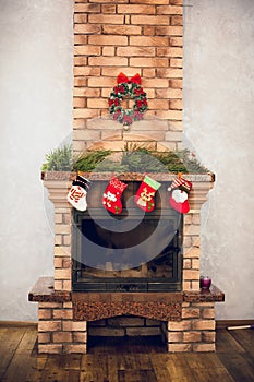 Home decorative fireplace made of bricks with candles, decorated with New Year\'s details