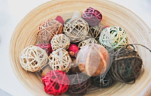 Home details decorations lying on the shelf. Wooden background. Loft style. Cosy rustic mood. Straw and rattan balls in vase