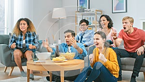 At Home Diverse Group of Sports Fans Sitting on a Couch Watching Important Sports Game Match on TV