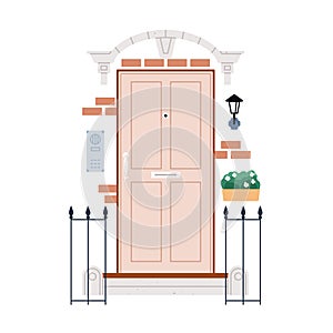 Home door with decoration outside. Front entrance with fence, potted plant, lamp, brick house wall. Facade, exterior of