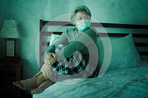 Home dramatic portrait of  attractive middle aged woman 50s with grey hair and protective mask during covid-19 virus lockdown