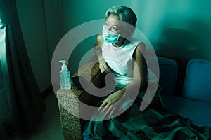 Home dramatic portrait of  attractive middle aged woman 50s with grey hair and protective mask during covid-19 virus lockdown