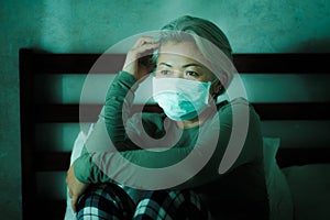 Home dramatic portrait of  attractive middle aged woman 50s with grey hair and protective mask during covid-19 virus lockdown