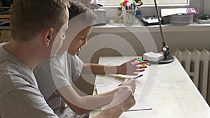 Home education - father and son discussing topic at desk