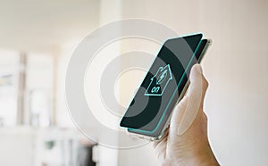 Home electrical system active icon on smartphone screen holding in a hand.
