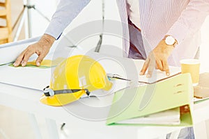 Home engineer builder working at desk with floor plan design photo
