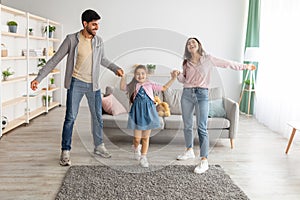 Home entertainment. Joyful arab family dancing to music with his cute daughter, having fun and enjoying time together