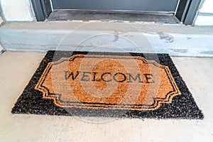 Home entrance with Welcome doormat in front of the doorstep and gray front door