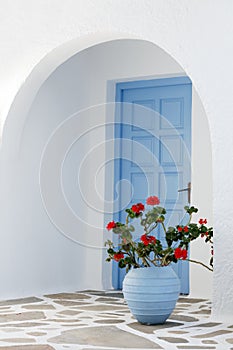 Home exterior with blue door and flowers in Greece