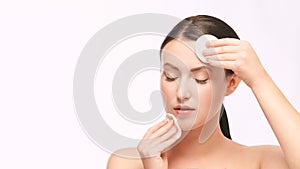 Home face care. Girl remove makeup. Woman hand with pad. Skin clean with cotton photo