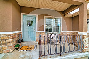 Home featuring blue front door and open porch with steps and curved railing