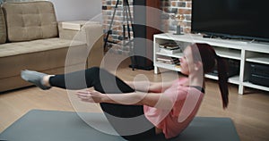 Home fitness concept. Woman doing strength training abs situps bodyweight floor exercises.