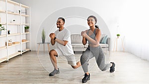 Home fitness. Full length of motivated black couple doing lunges in living room, banner design