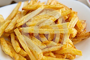 At home, french fries. close-up of finely chopped fried potatoes on white plate