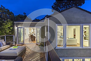 Home with furniture patio / wooden deck at twilight.