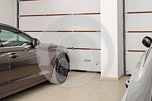 Home garage for two vehicles interior. Clean luxury cars parked at home. Automatic remote control doors. Transport roofed storage