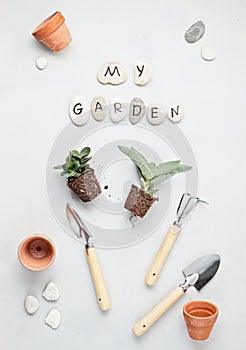 Home gardening concept. Flat lay with the text my garden on stones and gardening tools