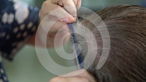 Home hairdresser cutting mans hair at indoors. Wife cutting husbands hair during quarantine