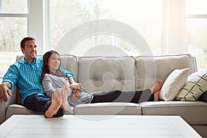 Home is having someone to love by your side. a happy young couple relaxing together on the sofa at home.