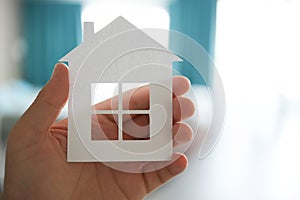 Home or house model on man hand in pastel color room background. Investment wealthy freedom life concept