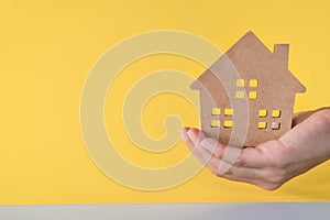 Home or house model on woman hand in color room background. Investment wealthy freedom life concept
