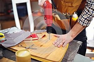 Home improvement - handyman drilling wood in workshop