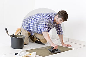 Home improvement - handyman laying tile photo