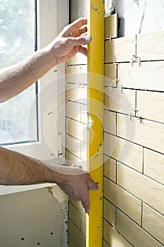 Home improvement - handyman measures straightness of the wall.