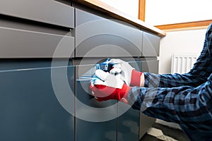 Home Improvement, handyman removing protective film on newly installed kitchen counter doors