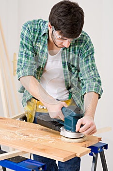 Home improvement - handyman sanding wooden floor photo