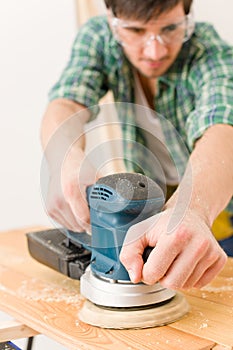 Home improvement - handyman sanding wooden floor photo