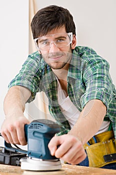 Home improvement - handyman sanding wooden floor photo