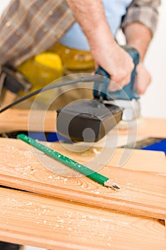 Home improvement - handyman sanding wooden floor photo