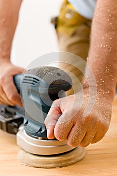 Home improvement - handyman sanding wooden floor photo