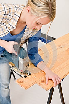 Home improvement - handywoman cutting wooden floor photo