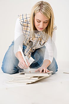 Home improvement - handywoman measuring tile photo